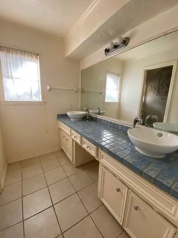 a bathroom with a granite countertop sink a mirror and vanity