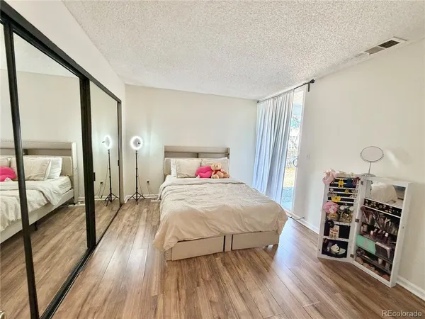 a bedroom with a bed and a wooden floor