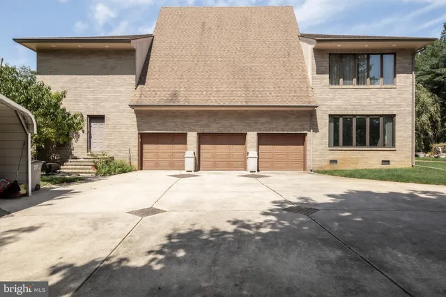 a view of a house with a big yard plants and large trees
