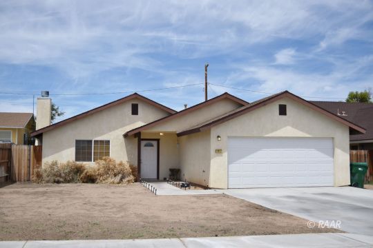 1117 South McCall Street Ridgecrest, CA 93555 - Photo 1 of 11 a front view of a house with yard and garage