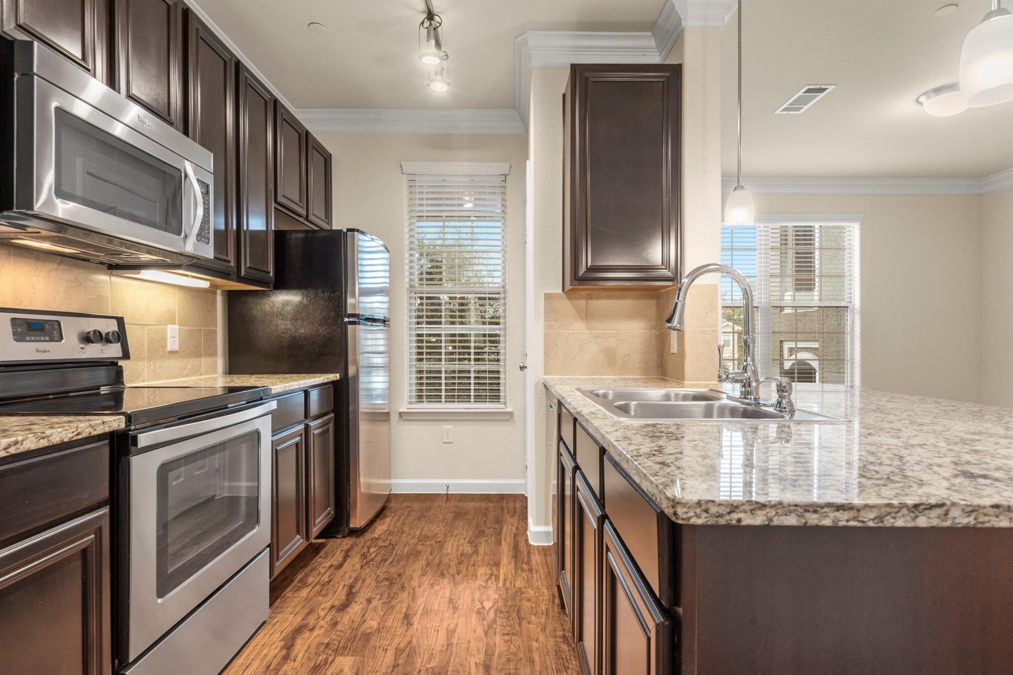 a kitchen with stainless steel appliances granite countertop a sink stove and refrigerator