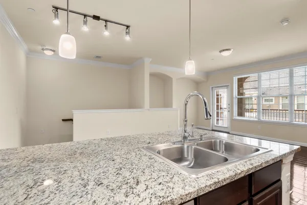 a kitchen with a sink a counter space and a wooden floor