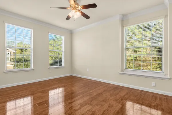 a view of an empty room with a window and wooden floor