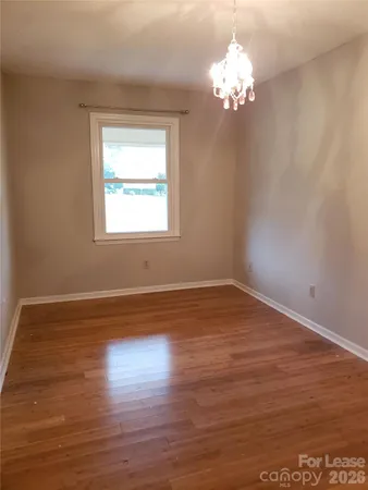 a view of a room with wooden floor and a chandelier