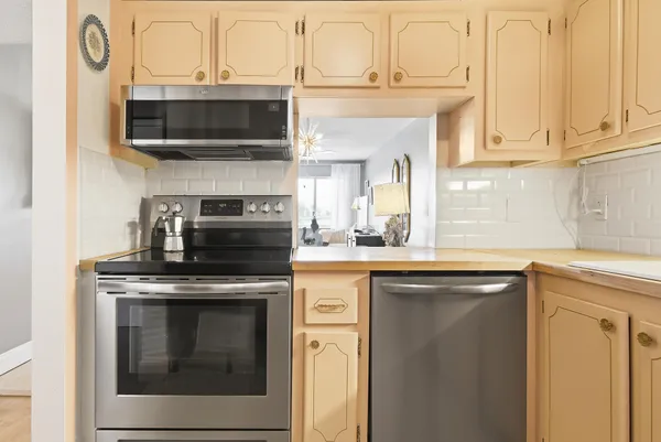 a kitchen with stainless steel appliances granite countertop a stove top oven microwave and cabinets