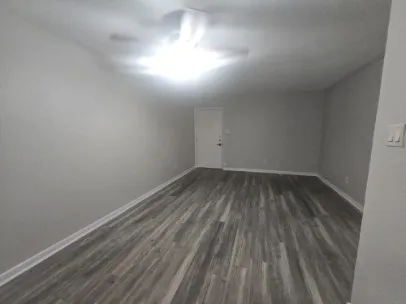 a room with wooden floor and windows