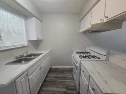 a kitchen with sink a stove and cabinets