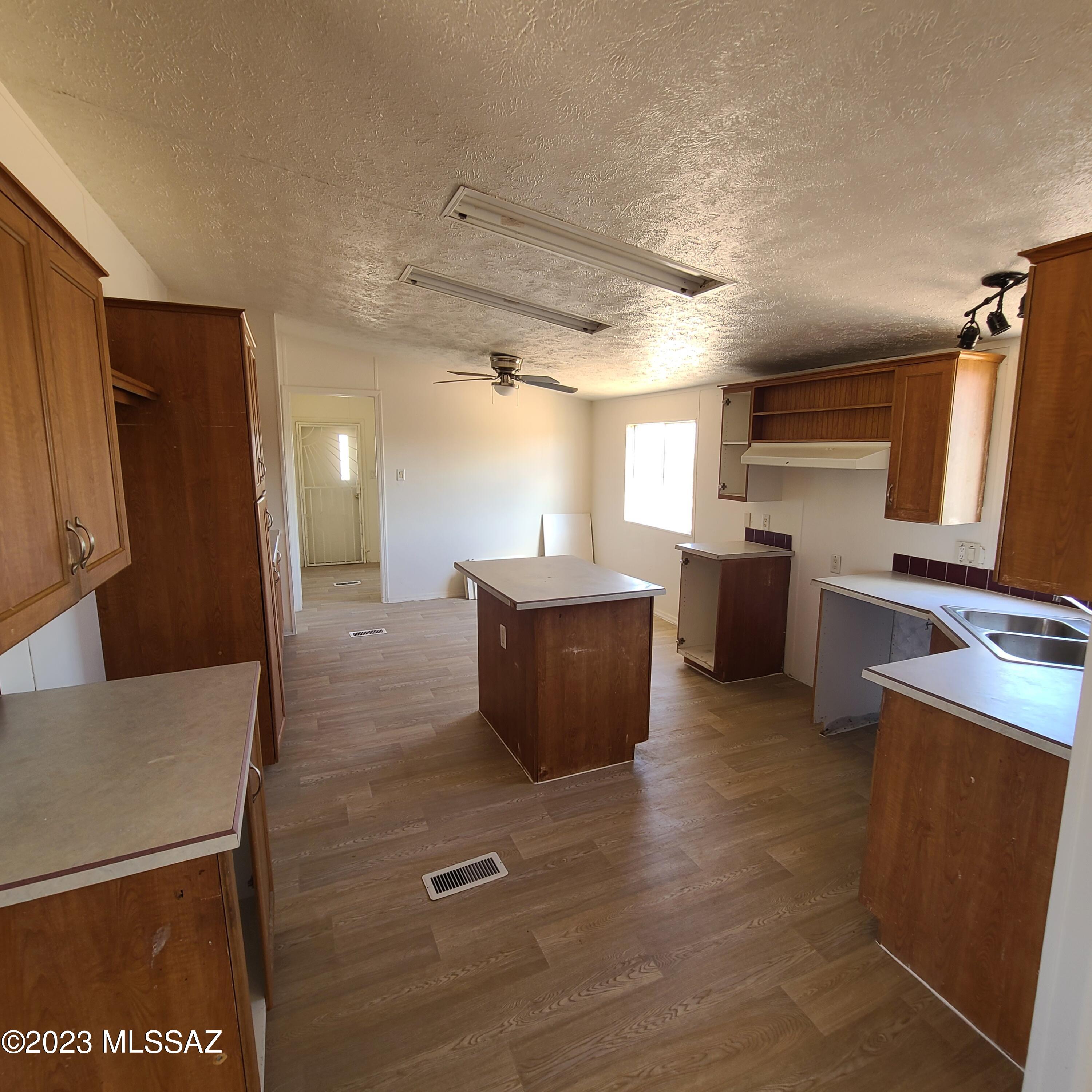 8896 South Marstellar Road Tucson, AZ 85736 - Photo 11 of 39 a kitchen with stainless steel appliances wooden cabinets a refrigerator and a stove