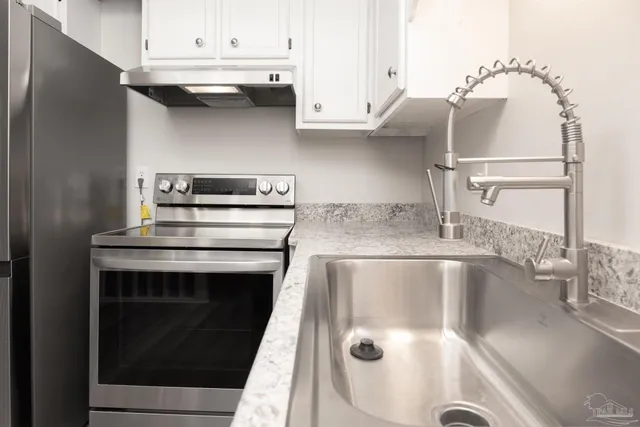 a view of an empty room with wooden floor fireplace and a window