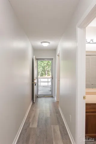 a view of a hallway with a livingroom and a bathroom