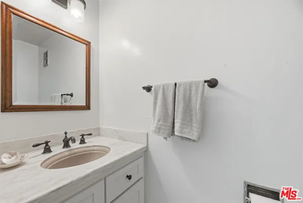 a bathroom with a granite countertop sink and a mirror