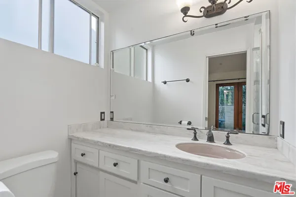 a bathroom with a granite countertop sink and a mirror