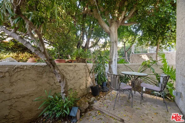 a view of patio with table and chairs and potted plants