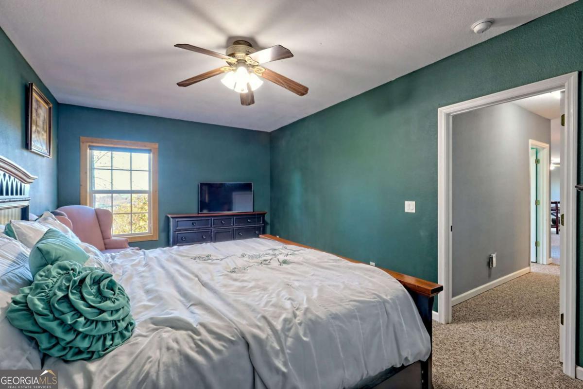 1279 Harris Ridge Road, Unit 24 Young Harris, GA 30582 - Photo 67 of 81 a bedroom with a large bed and a chandelier