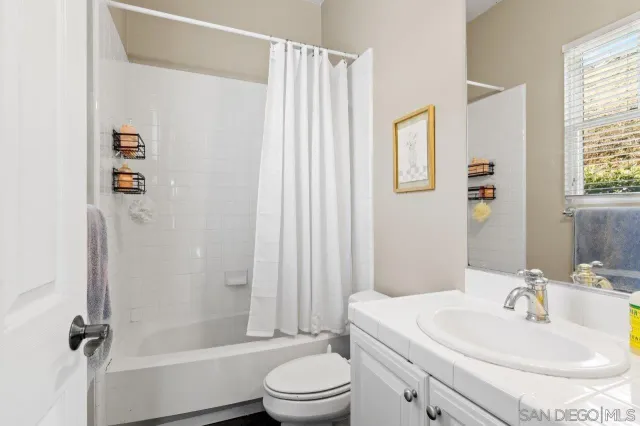a view of a dining room and livingroom with furniture wooden floor a chandelier