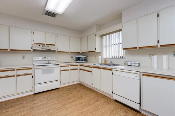 a view of a kitchen with furniture and wooden floor