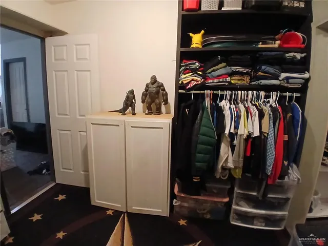 a view of walk in closet with clothes and shoes