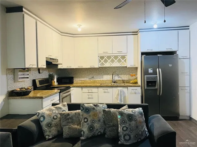 a kitchen with stainless steel appliances a refrigerator sink and cabinets