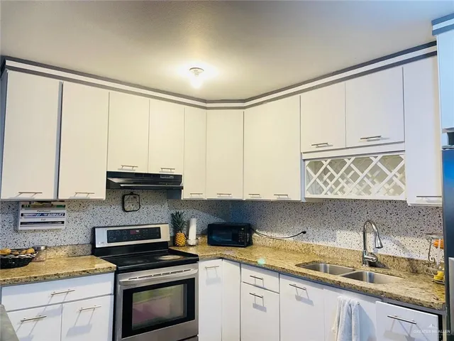a kitchen with stainless steel appliances granite countertop a sink and a stove