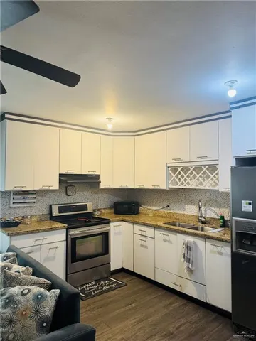 a kitchen with a sink white cabinets and white appliances