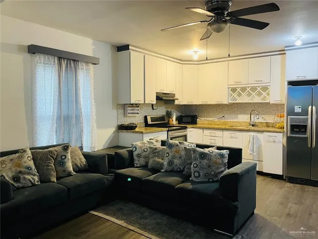 a living room with furniture and a ceiling fan