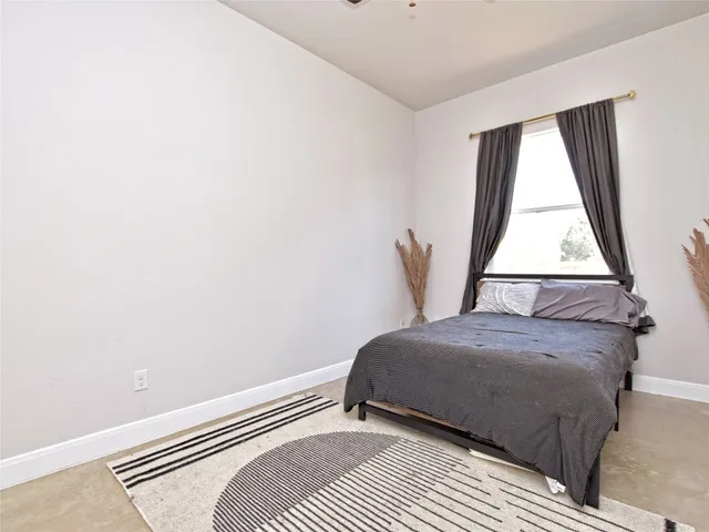 a bedroom with a bed and a window