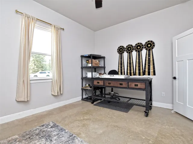 a view of a workspace with furniture and a window