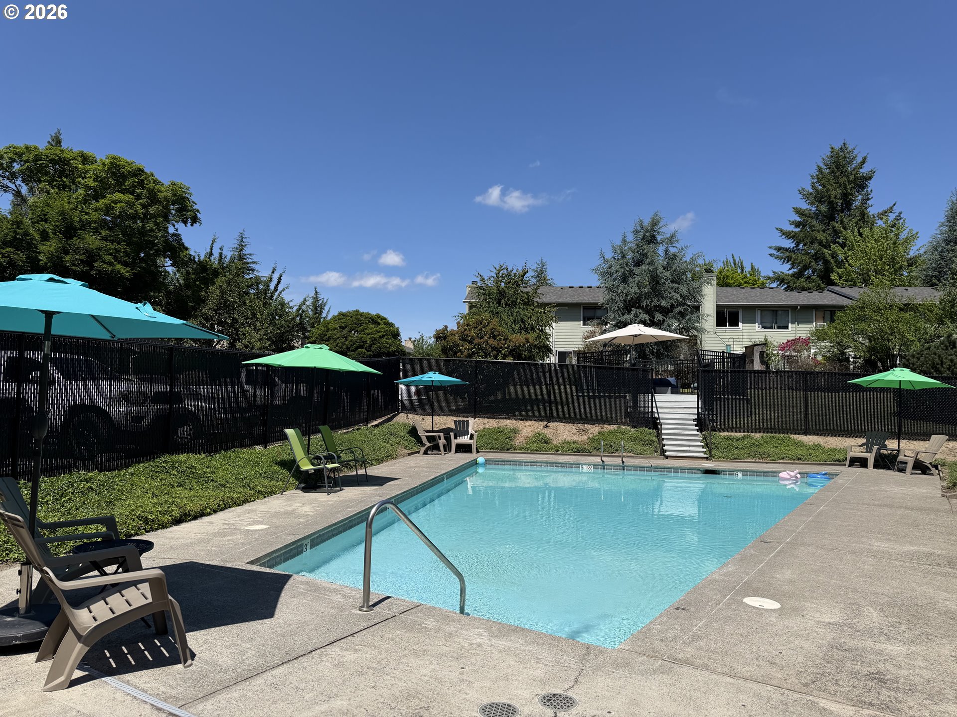 29640 Southwest Volley Street, Unit 40 Wilsonville, OR 97070 - Photo 25 of 25 a view of a swimming pool with lawn chairs under an umbrella