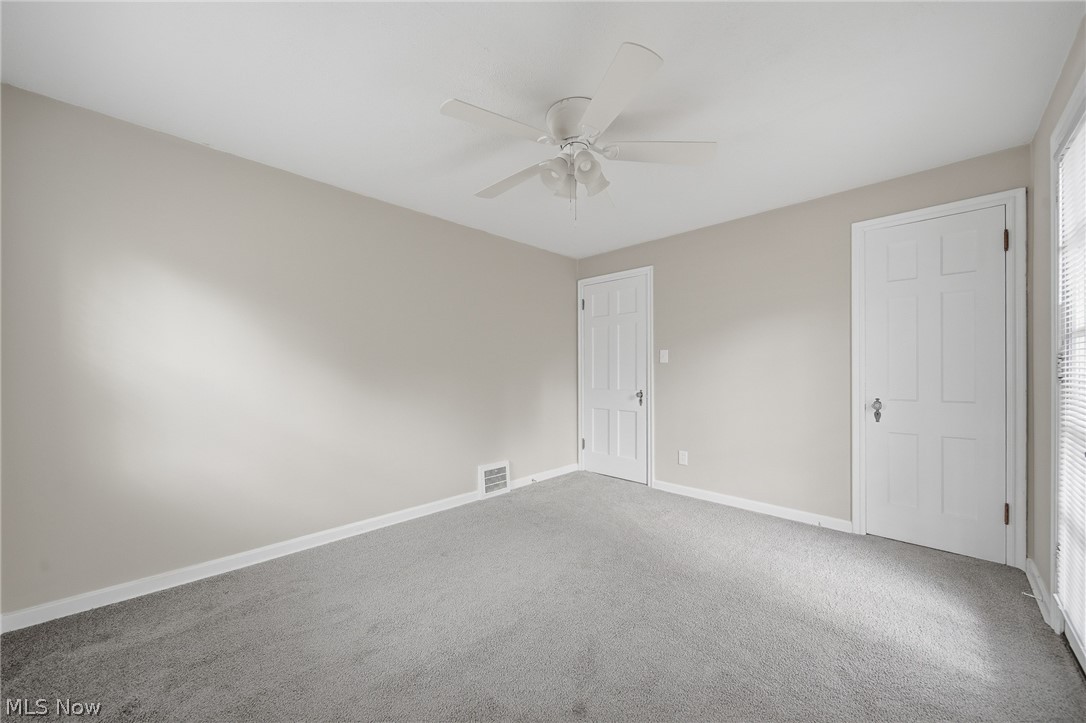 2231 Brockway Road University Heights, OH 44118 - Photo 16 of 46 Carpeted room featuring a ceiling fan with light fixture, neutral wall paint, white trim, and two white paneled doors
