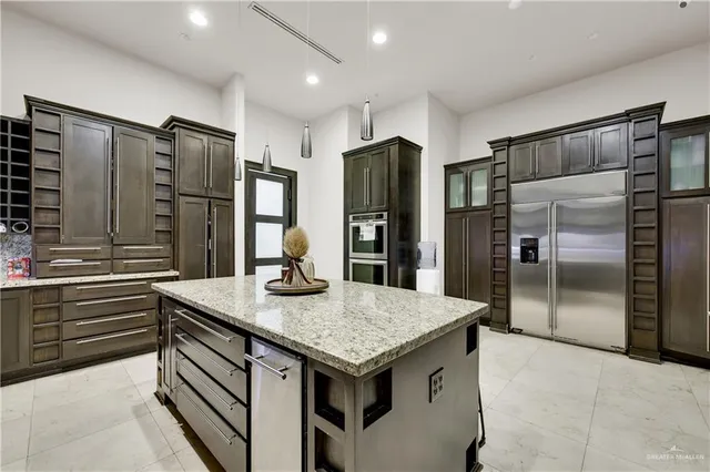 a kitchen with stainless steel appliances granite countertop a refrigerator and a sink