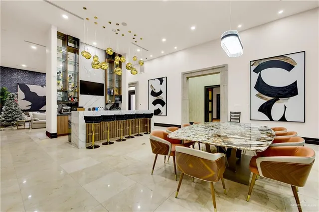 a dining room filled chandelier and kitchen view