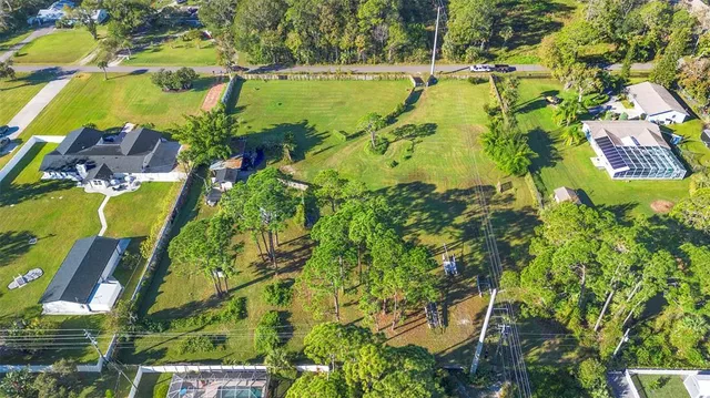 an aerial view of residential houses with outdoor space and swimming pool