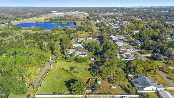 an aerial view of residential houses with outdoor space and trees
