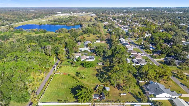 an aerial view of residential houses with outdoor space and trees