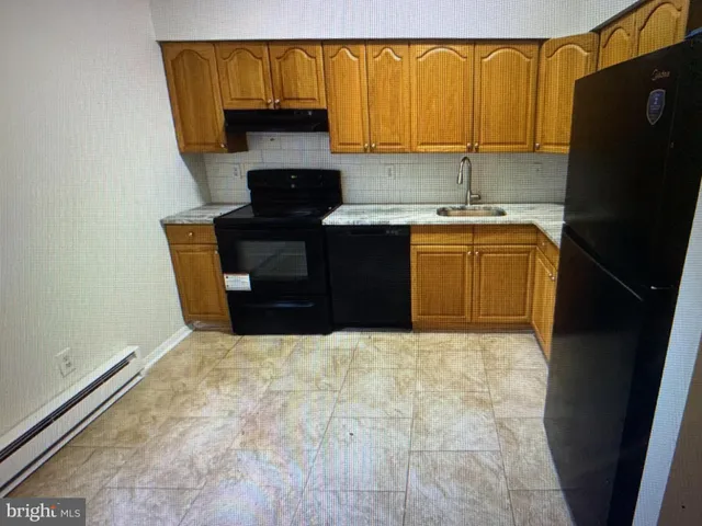 a kitchen with a sink a refrigerator and a stove