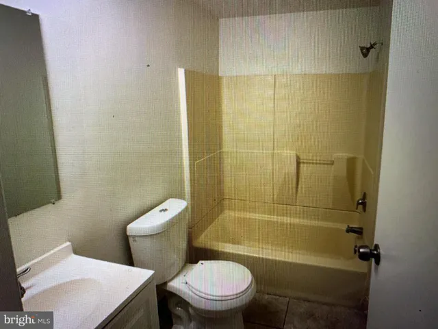 a white toilet sitting next to a bath tub and a shower