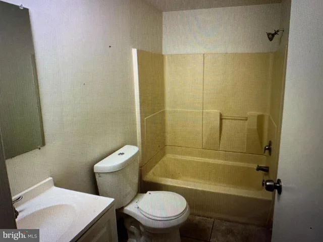 a white toilet sitting next to a bath tub and a shower