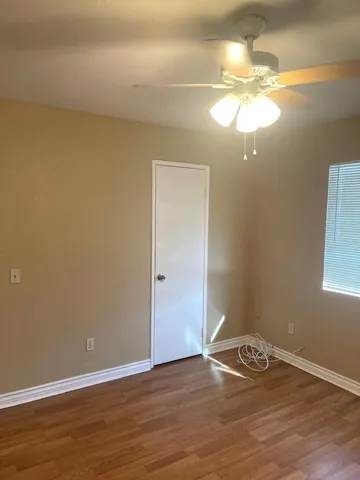 a view of room with wooden floor and fan
