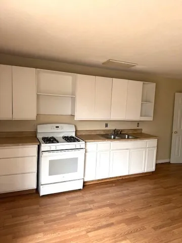 a kitchen with a stove and white cabinets