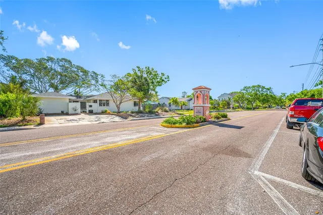 a street view with flower plants and wooden fence