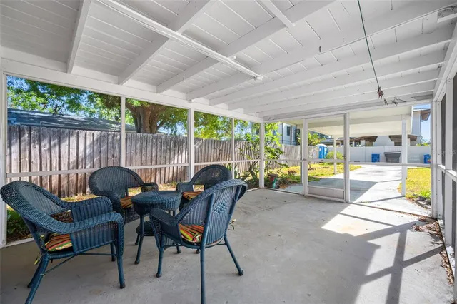 a view of a patio with table and chairs potted plants with wooden floor and fence