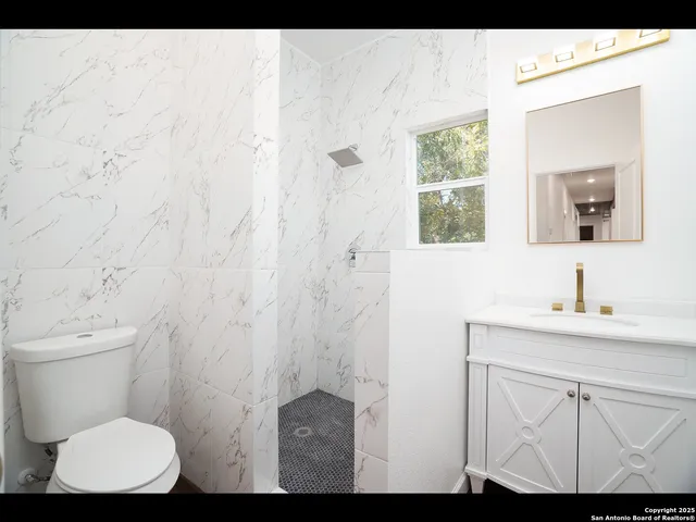 a bathroom with a toilet a sink and a window