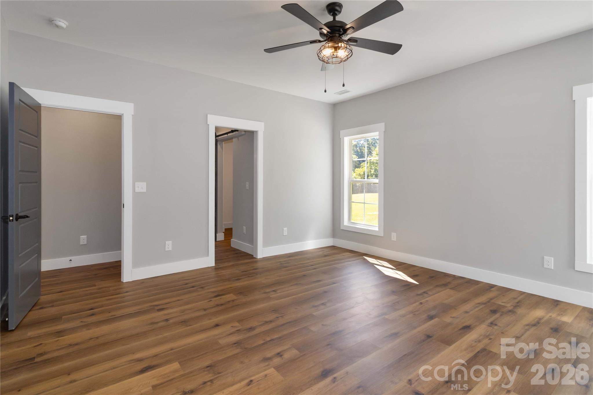 2605 Mt Prospect Road Chester, SC 29706 - Photo 16 of 31 an empty room with wooden floor chandelier fan and windows