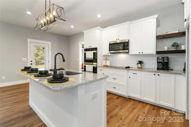 a kitchen with sink a microwave and cabinets
