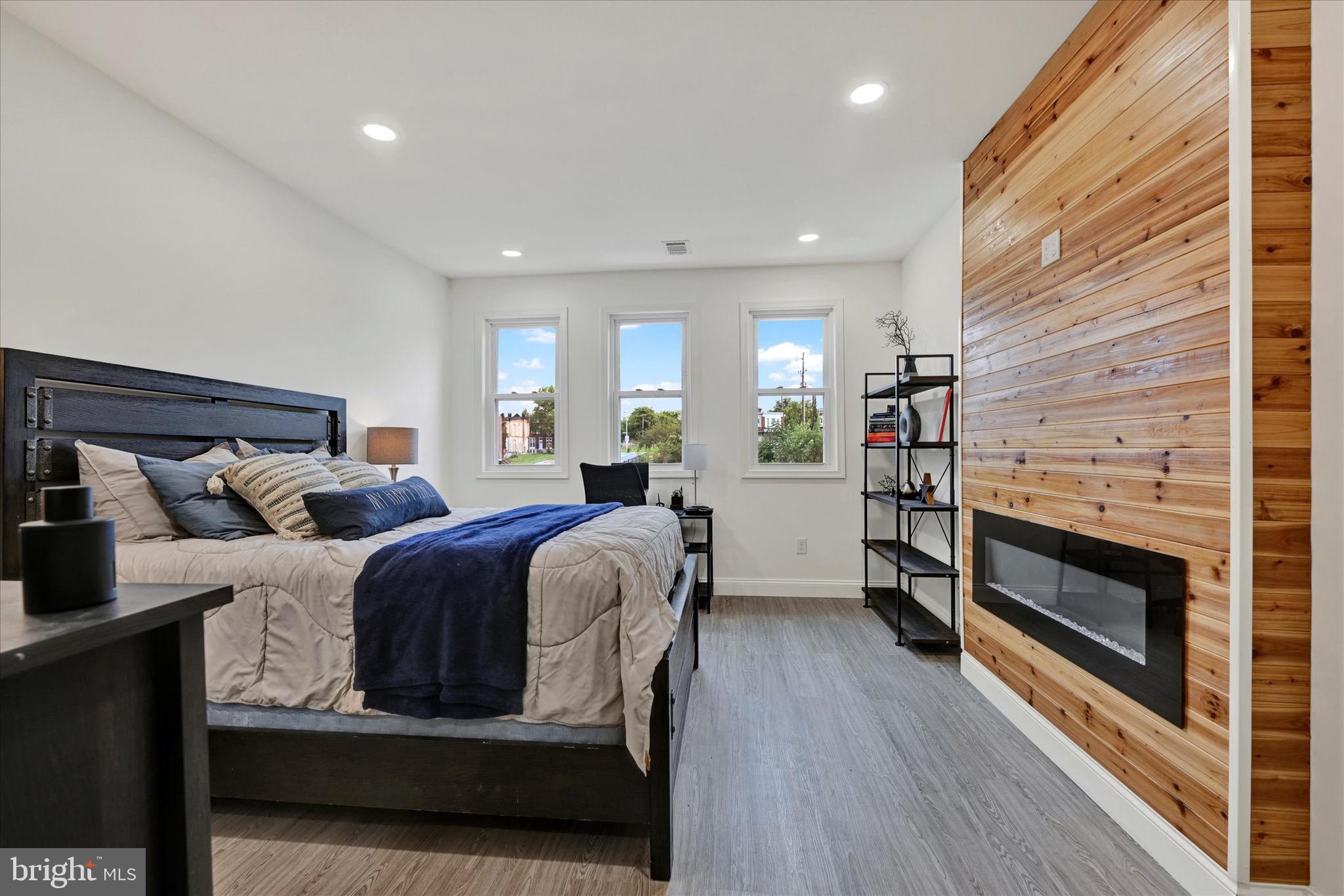 1748 North Chester Street Baltimore, MD 21213 - Photo 16 of 27 a living room with a bed furniture a fireplace and a wooden floor