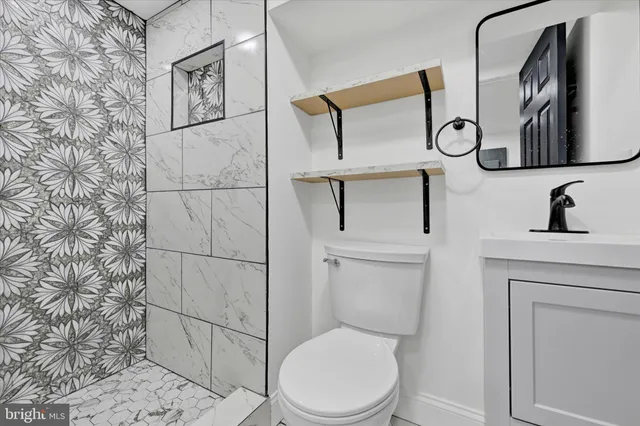 a bathroom with a toilet sink and mirror