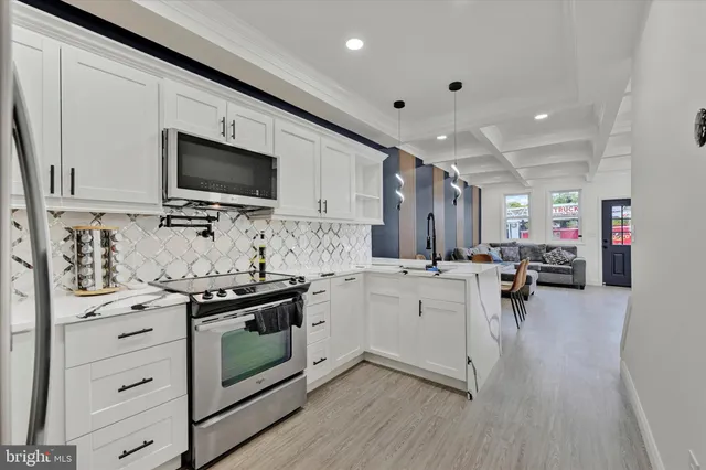 a kitchen with stainless steel appliances a stove sink microwave and cabinets
