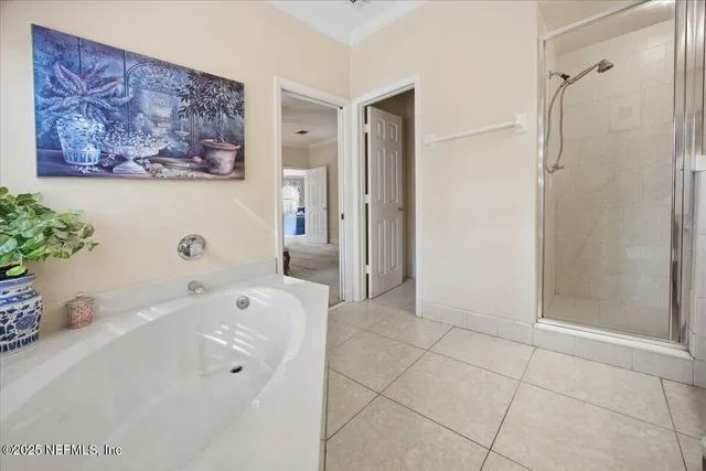 a spacious bedroom with a bed a dresser and next to a window