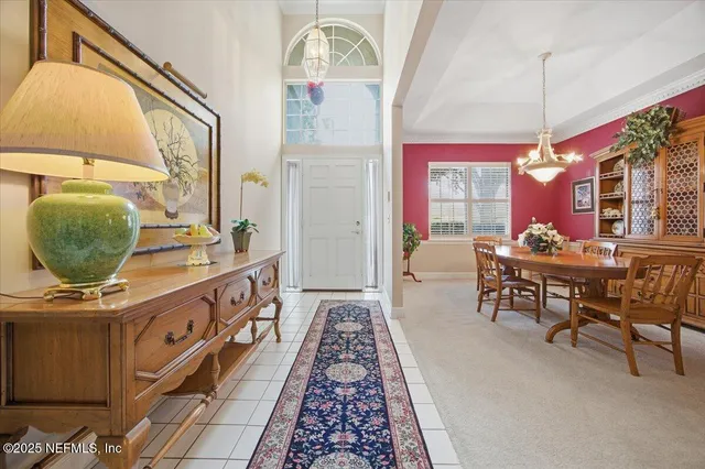 a room with table chairs and a potted plant