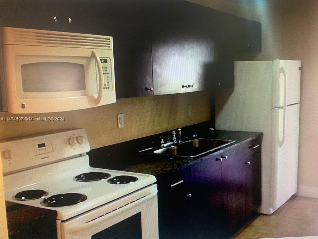 180 Northeast 71st Street, Unit 2 Miami, FL 33138 - Photo 7 of 10 a kitchen with a stove and a refrigerator